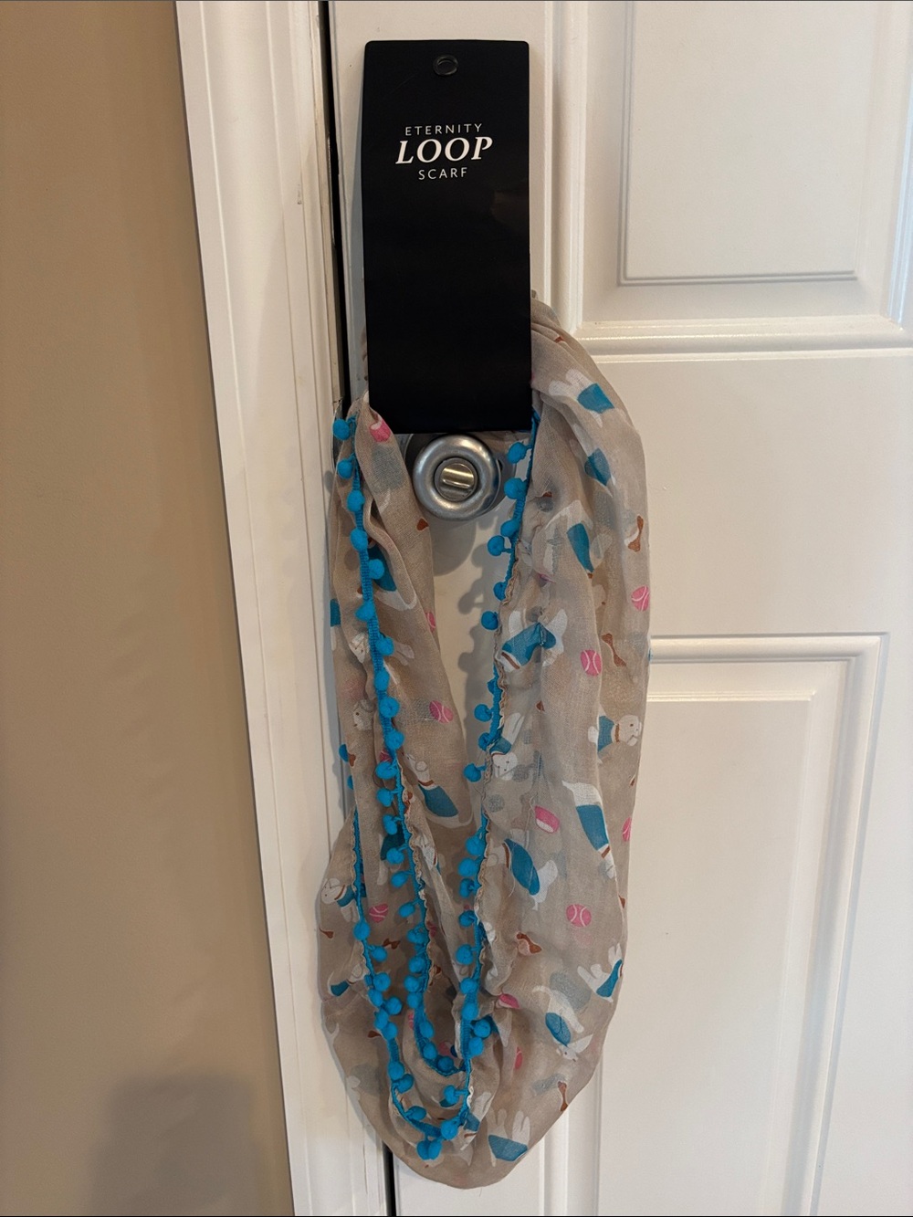 The Accessory Collective Beige Loop Scarf with Blue Pom Trim